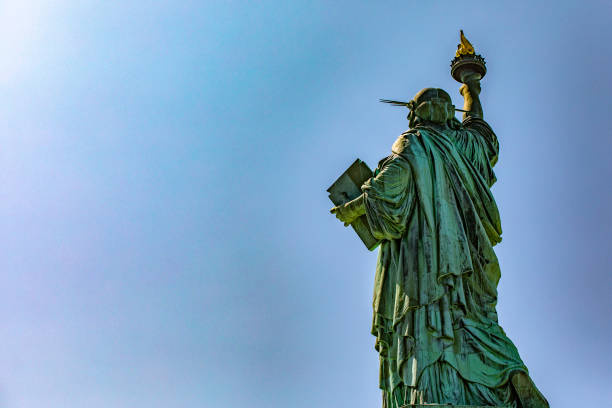 la statue de la liberté à new york, sous une journée ensoleillée dans la grosse pomme avec le ciel bleu de new york aux états-unis d’amérique. - statue apple roman sculpture photos et images de collection