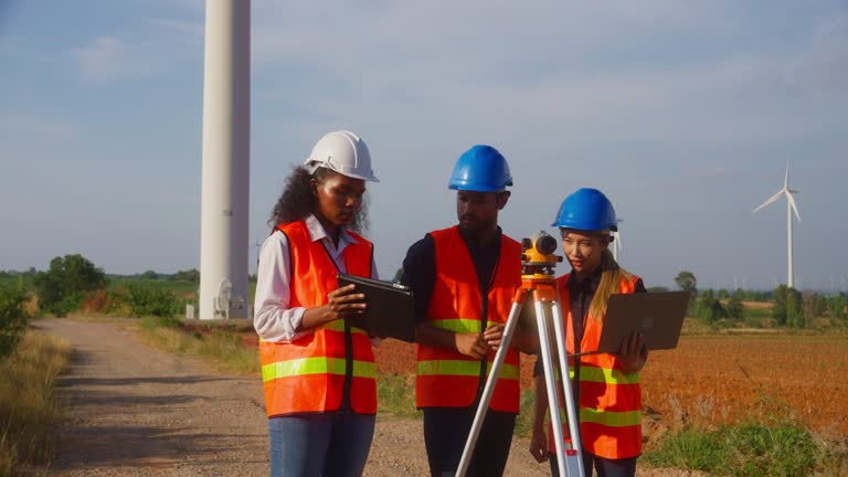 Young engineer and woman taking notes and looking through the survey camera.