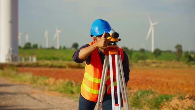 A young engineer is looking through a survey camera.