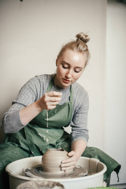 istock Young Woman learning pottery on a potter's wheel 1886527524