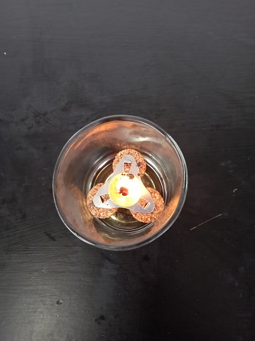 a small burning candle in the glass