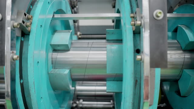 Close up shot of rotating machine parts of the machinery. Automated machine operation at the paper products manufacturing for enhancing productivity with efficiency.
