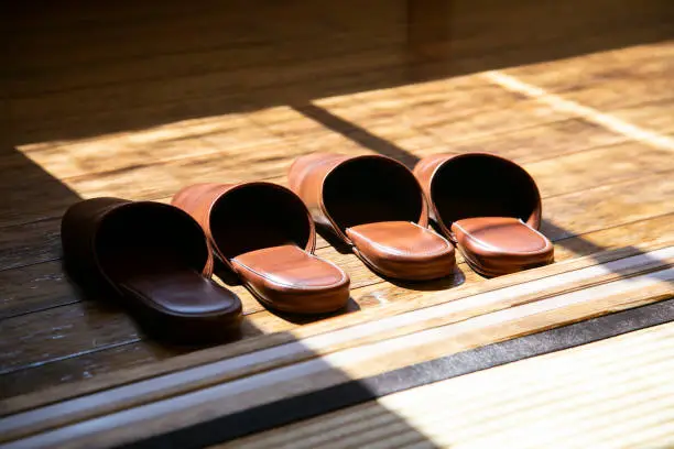 Photo of Domestic leather slippers at the entrance of a Japanese house with wooden floors.