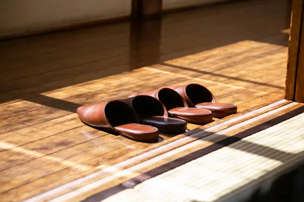 Photo of Domestic leather slippers at the entrance of a Japanese house with wooden floors.