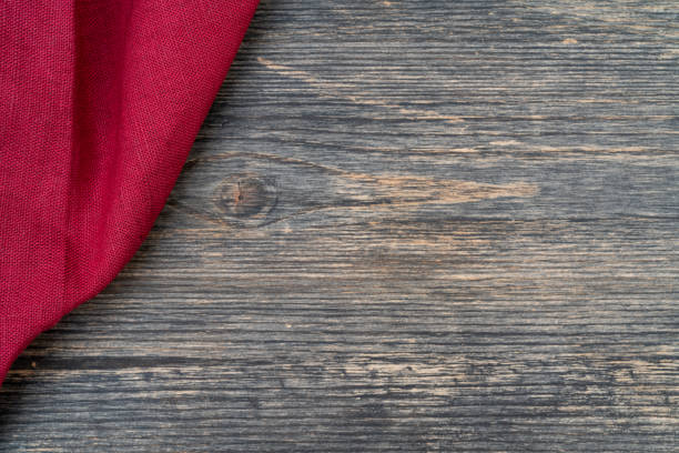 Red towel on the kitchen table. Wooden table background.