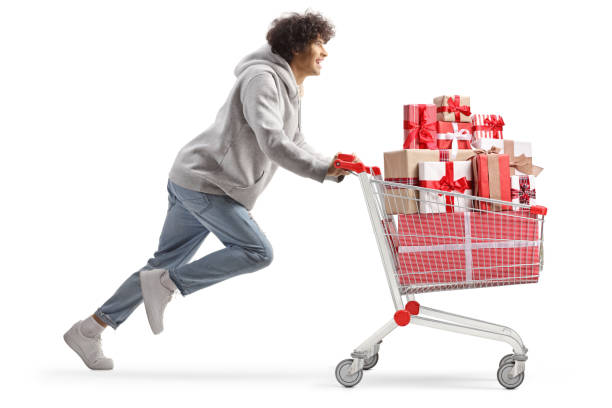 istock Young man running with present boxes in a shopping cart 1886644666