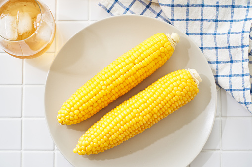 Simple boiled corn on the cob served on a plate.