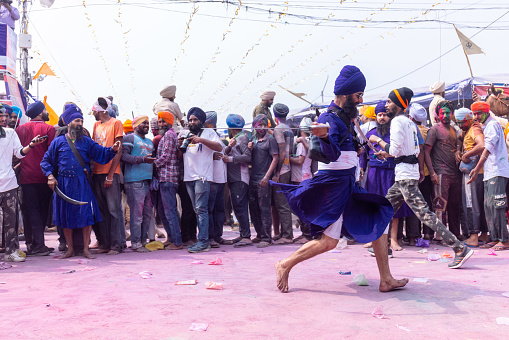Anandpur Sahib, Punjab, India - March 19 2022: Portrait of sikh male (Nihang Sardar) performing martial art as culture during the celebration of Hola Mohalla at Anandpur Sahib during holi festival.