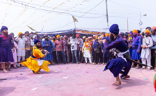 Anandpur Sahib, Punjab, India - March 19 2022: Portrait of sikh male (Nihang Sardar) performing martial art as culture during the celebration of Hola Mohalla at Anandpur Sahib during holi festival.
