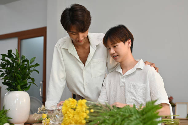 portrait with asian gay couple, they are helping to arrange a bouquet of flowers in the house. - florist flower arranging male стоковые фото и изображения