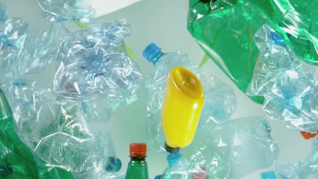 Super slow motion of empty plastic garbages flying into the air.