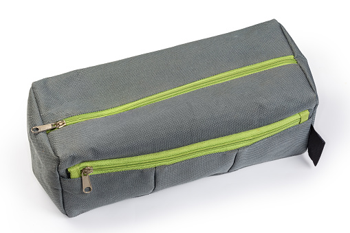 Small fabric gray travel toiletry bag with two green zippered closures on a white background