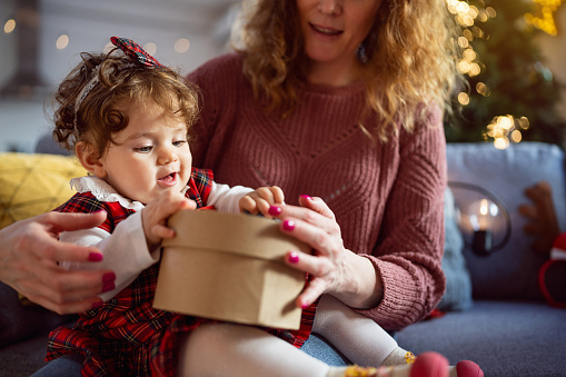 Portrait of an Caucasian baby girl holding an Christmas present