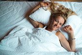 A woman wakes up in bed during the morning