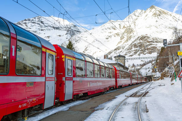 December 24, 2023, Switzerland, Europe: Bernina Express, red train with panoramic windows in the alpine mountains  covered with snow.
