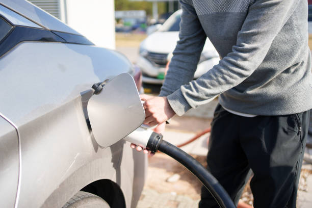 istock Hand holding a charging gun to charge the car 1886843288