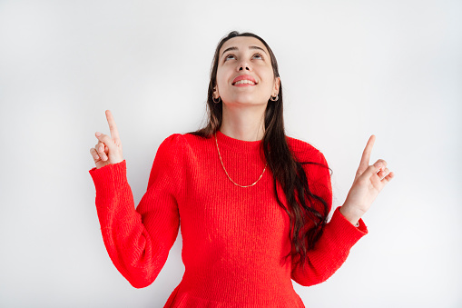 Young woman showing index finger up, over white background