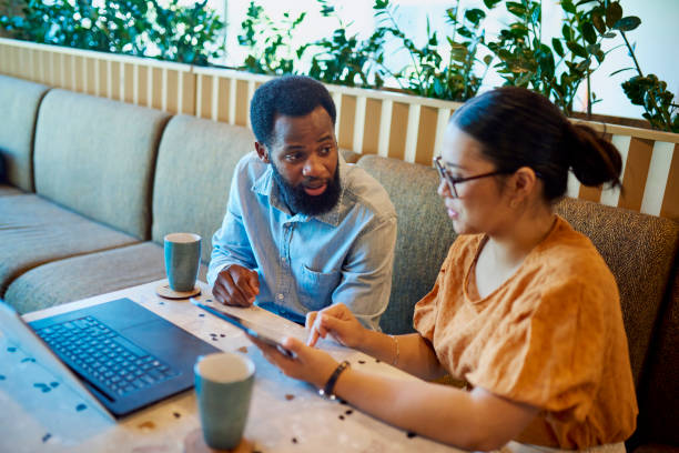 istock Multiracial business people discussing work with digital devices in breakout space 1886852151