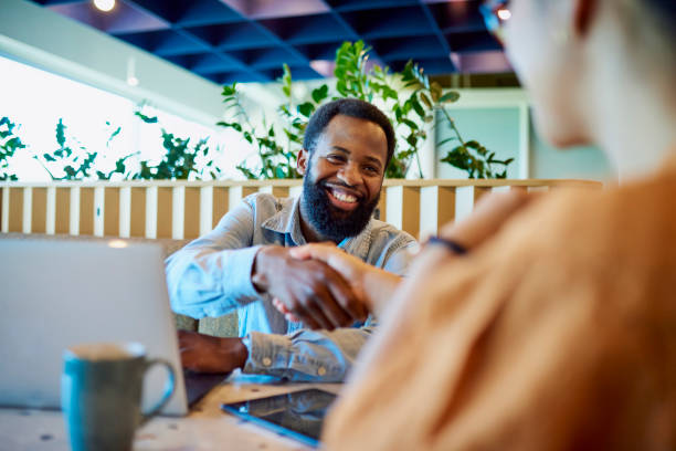 istock Bearded businessman shaking hands with business partner in breakout space 1886852155