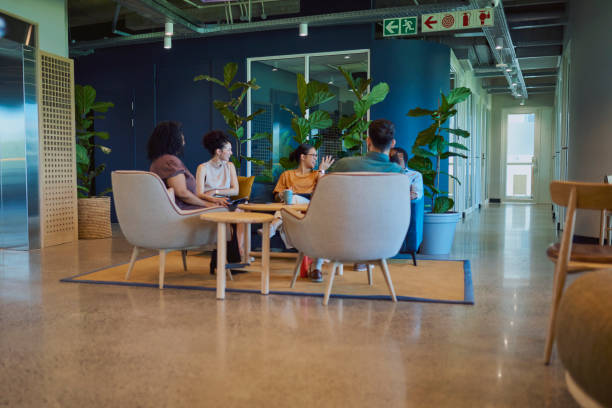 istock Project teammates discussing work at team meeting in office breakout space 1886852693