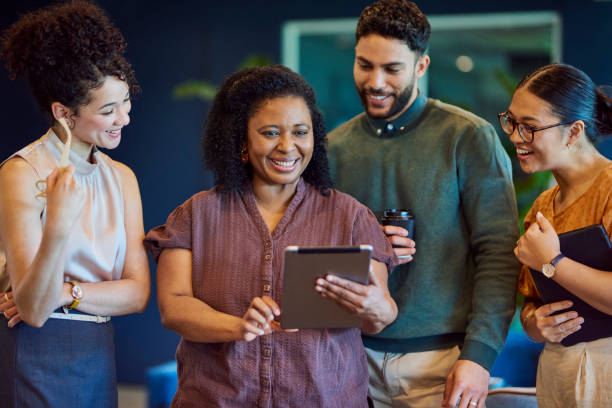 istock Office colleagues smiling happily at digital tablet in office breakout space 1886852715