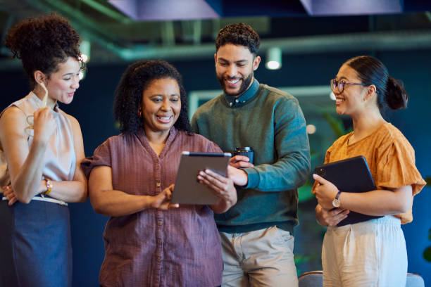 istock Office colleagues using digital tablet and smiling in office breakout space 1886852722