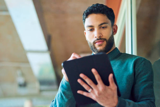 istock Low angle view of young businessman using digital tablet in office 1886852730