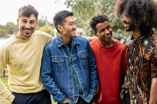 group of young adult multiracial male friends talking and laughing with each other