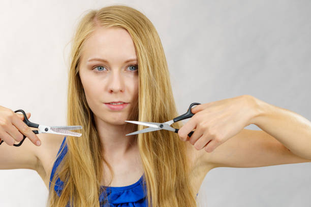 istock Girl with scissors for haircutting 1886859729