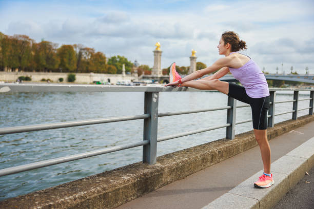 istock Active young woman stretching leg on railing after workout at city waterfront 1886873775