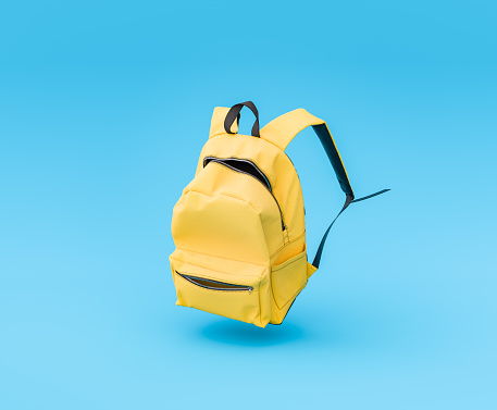 3D rendering of a vibrant yellow backpack suspended in the air on a solid blue background, concept of education and learning.