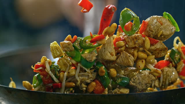 SLO MO Chicken stir fry being tossed in a wok