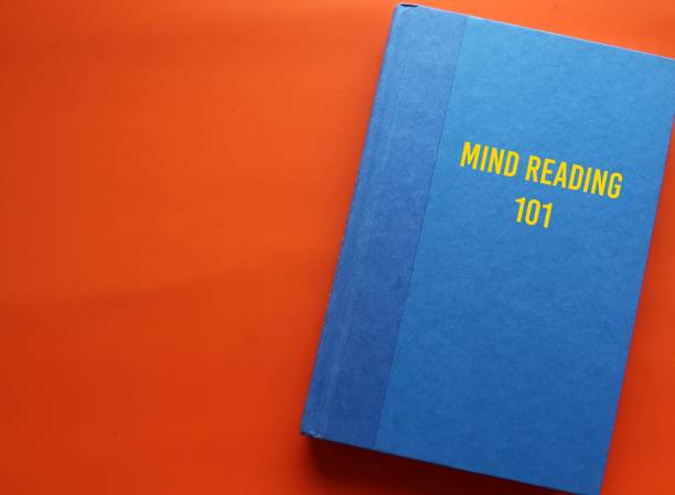 istock Blue book with text written on cover MIND READING 101 - means ability to know what is going on in someone's mind without asking them to clarify 1886911548
