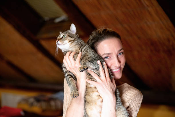 istock Happy woman holding her cat affectionately and smiling at camera 1886938498
