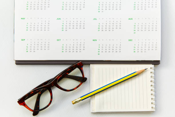 istock Desk calendar 12 months year 2025 with glasses notepad and pencil, object background 1886979798