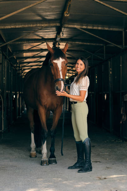 istock Cheerful equestrian with horse in stall 1886986088