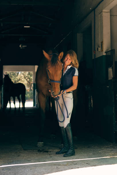 istock Happy equestrian with horse in barn 1886986612