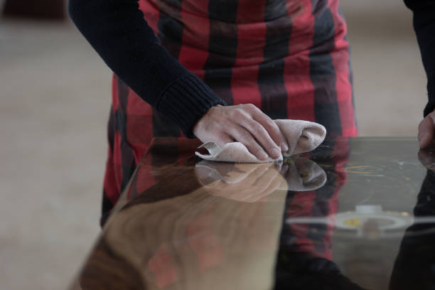 istock A carpenter removes dust with a cloth while finishing the table top 1886987704