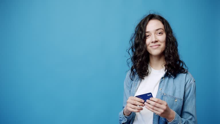Happy young brunette with credit card.