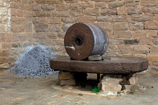 The ancient old stone grain mill gristmill grinding wheat or grains into flour using millstone quern stone in the serbian house