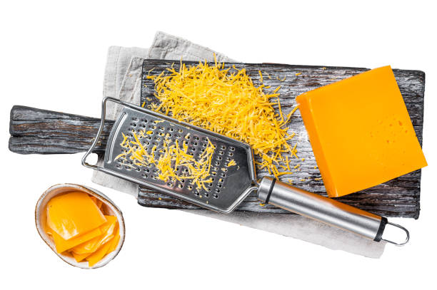 istock Grated Cheddar Cheese on a wooden cutting board.  Isolated on white background, top view. 1887064710