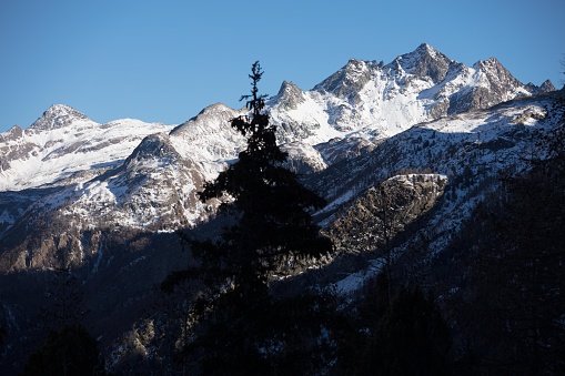 The mountain peaks surrounding the village stand out in the dim light of the late winter afternoon.