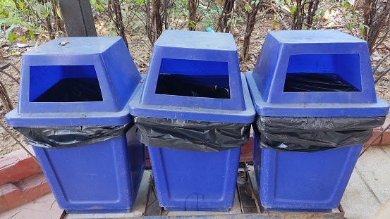 3 blue trash cans