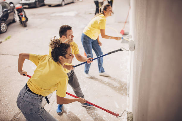 istock Volunteers painting building wall 1887149070