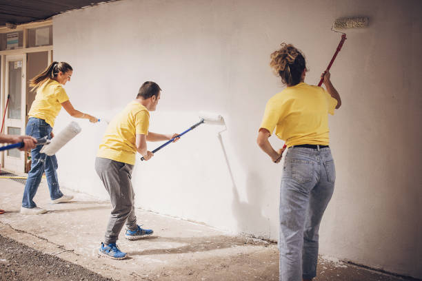 People painting building wall