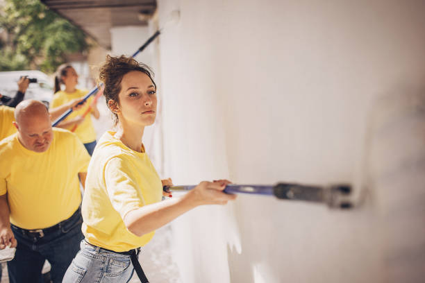 istock Volunteers painting building wall 1887168506