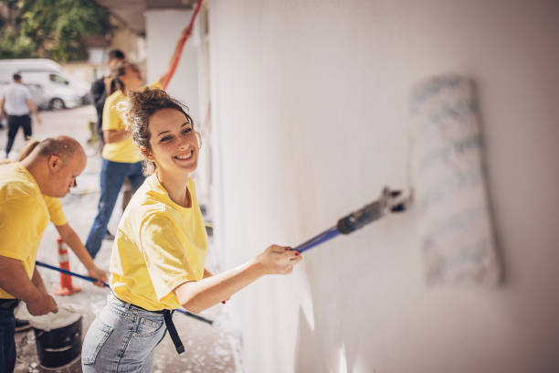 istock Volunteers painting building wall 1887169528