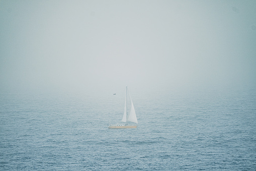 Sailboat in the ocean in the dust of calima on the Canary Islands, Spain.