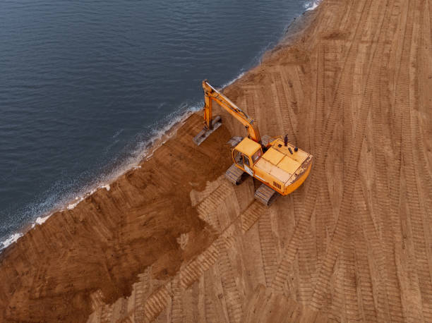 istock Excavator machine doing an earthwork on a shore.Aerial photography 1887212442