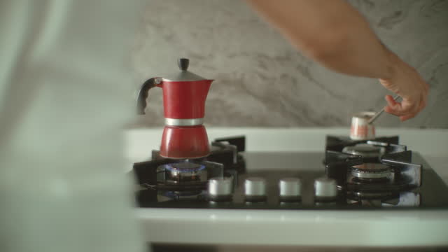 Man prepares coffee in a moka pot at home